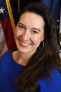 Portrait of Haley Day in front of the American and Kentucky flags.